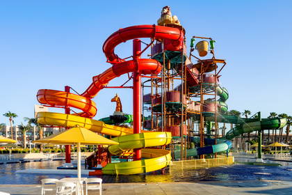 Kolorowy park wodny ze zjeżdżalniami i basenem.