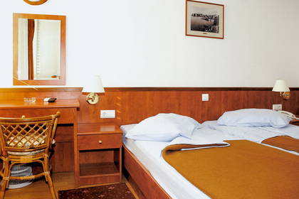Pokój hotelowy z łóżkiem, biurkiem i krzesłami.