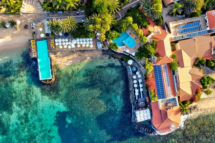 Nadmorski kurort z basenami i palmami, widok z góry.