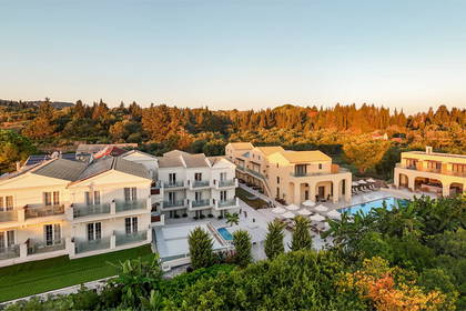 Kompleks hotelowy z basenem otoczony zielenią, widok z góry.
