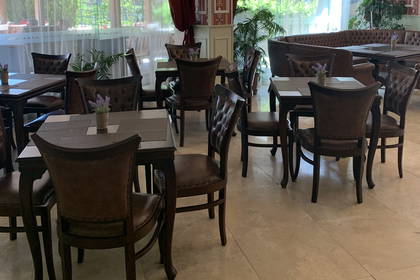 Restauracja z brązowymi krzesłami i stołami.
