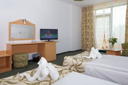 Pokój hotelowy z dwoma łóżkami i ręcznikami ułożonymi w kształt łabędzi.
