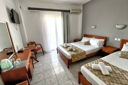 Pokój hotelowy z dwoma łóżkami, stołem i krzesłami.
