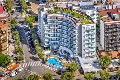 Hotel z basenem i tarasem na dachu widziany z góry.