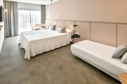Pokój hotelowy z dwoma łóżkami, sofą i oknem.