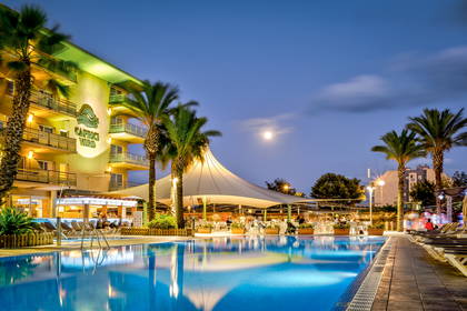 Hotel Caprice Verde nocą. Widok na basen i palmy.