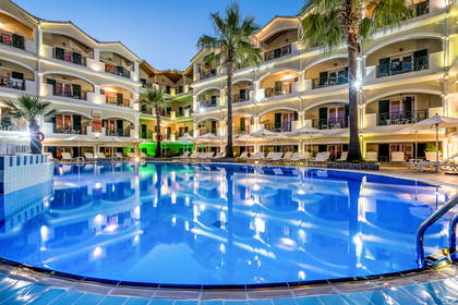 Hotel z basenem otoczonym palmami.