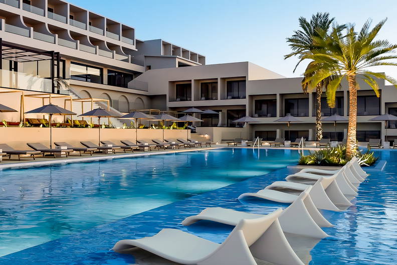 Hotelowy basen z leżakami i parasolami przeciwsłonecznymi.