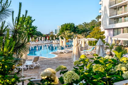 Basen z leżakami i parasolami przy hotelu.
