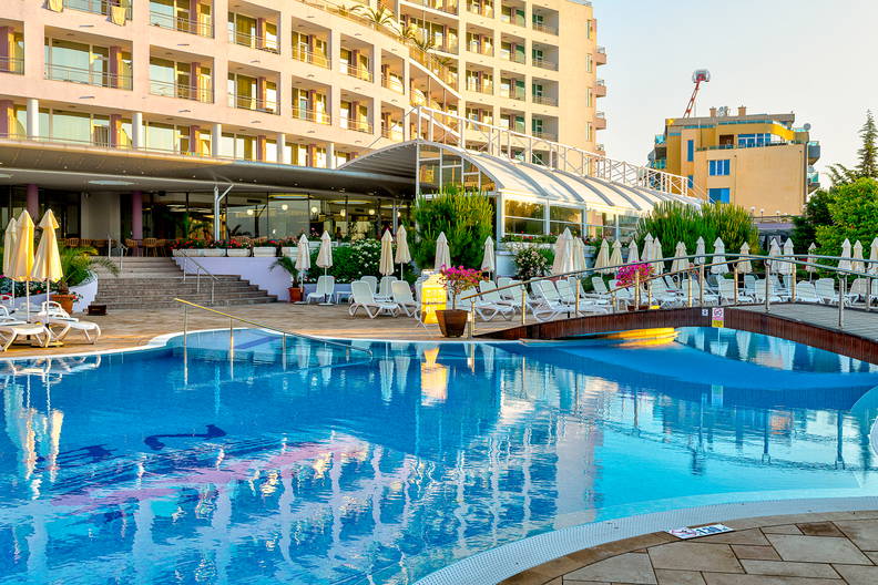 Basen hotelowy z mostkiem i leżakami.