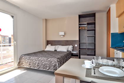 Pokój hotelowy z łóżkiem, szafą i stołem.