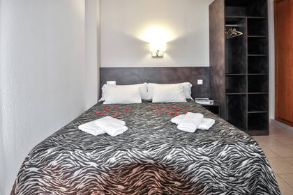 Pokój hotelowy z łóżkiem ozdobionym wzorem zebry i płatkami róż.