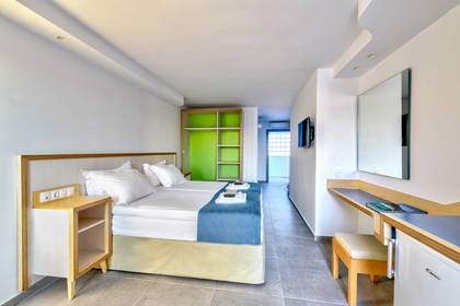 Pokój hotelowy z łóżkiem, biurkiem i szafką.