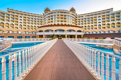 Hotel z basenami połączonymi mostkiem.