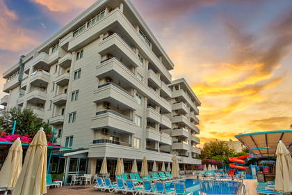 Hotel z basenem, leżakami i zjeżdżalnią.