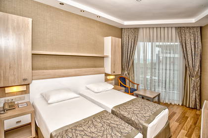 Pokój hotelowy z dwoma łóżkami, szafką nocną i balkonem.