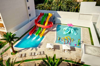Hotelowy park wodny z basenami, zjeżdżalniami i palmami (widok z góry).