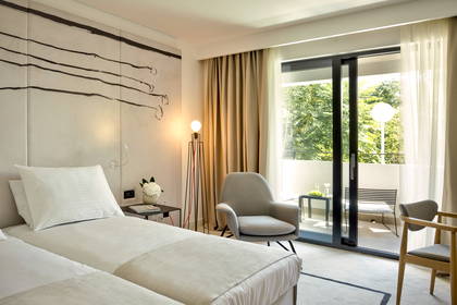Pokój hotelowy z dwoma łóżkami i balkonem.