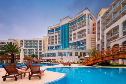 Luksusowy hotel z basenem i leżakami.