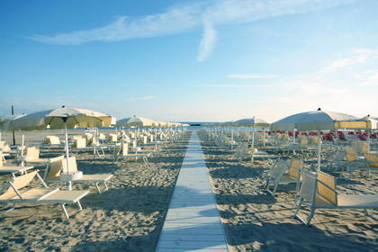 Plaża z leżakami i parasolami przeciwsłonecznymi.