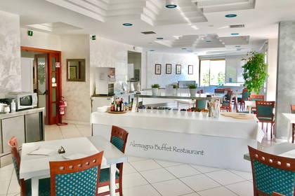Restauracja z białymi stolikami i bufetem.