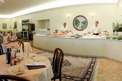Sala restauracyjna z bufetem i stolikami.