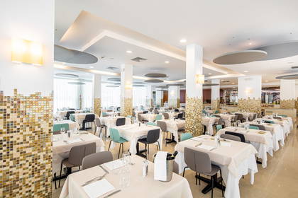 Jasne wnętrze restauracji z nakrytymi stołami.