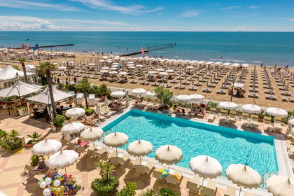 Basen i plaża z leżakami oraz parasolami, widok z góry.