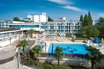 Hotel Zorna i basen w słoneczny dzień.