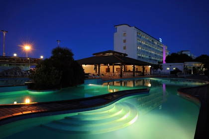 Oświetlony basen hotelowy nocą.