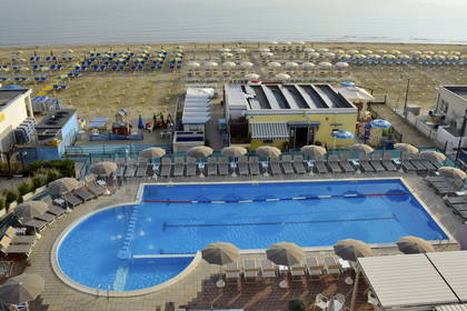 Widok z góry na basen, plażę i morze.