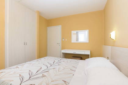 Pokój hotelowy z łóżkiem, szafą i toaletką.