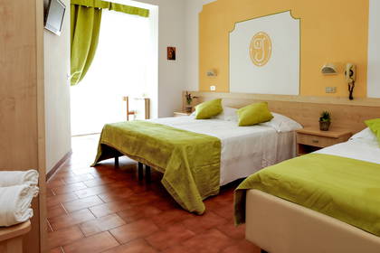 Pokój hotelowy z dwoma łóżkami i terakotową podłogą.