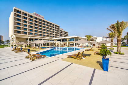 Hotel Hilton Garden Inn z basenem i leżakami.
