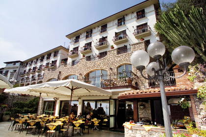 Hotel z patio, na którym siedzą goście.