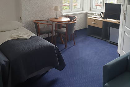 Pokój hotelowy z łóżkiem, stołem i krzesłami.