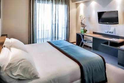 Pokój hotelowy z łóżkiem, biurkiem i telewizorem.