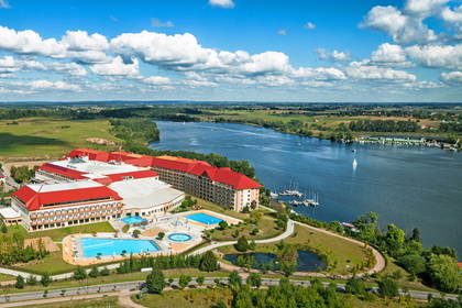 Panorama hotelu z basenami nad jeziorem.