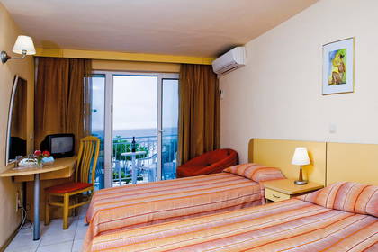 Pokój hotelowy z dwoma łóżkami i balkonem.