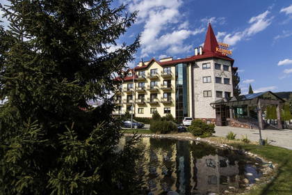 Hotel Klimczok z wieżą odbija się w stawie.