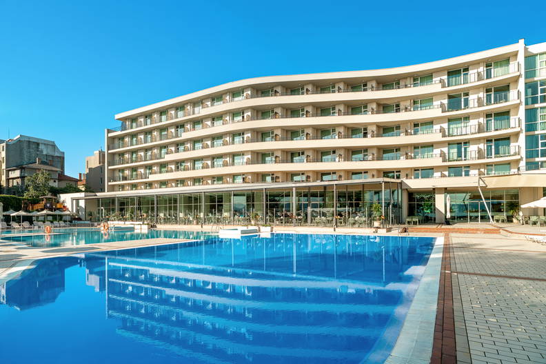 Hotel z basenem w słoneczny dzień.