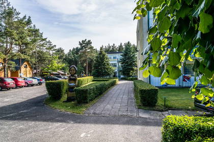 Park z rzeźbą kobiety i ścieżką spacerową.
