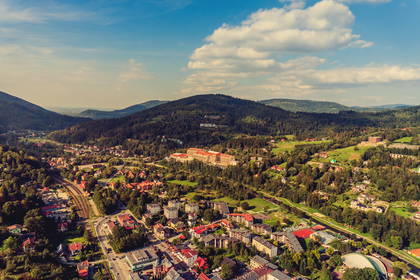 Panorama miasta w górach, widok na budynki i zieleń.