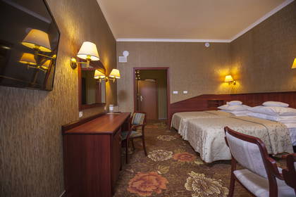 Pokój hotelowy z dwoma łóżkami, biurkiem i telewizorem.