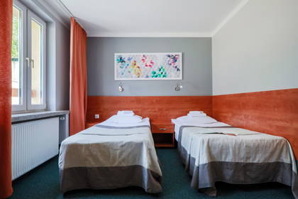 Pokój hotelowy z dwoma łóżkami pojedynczymi.