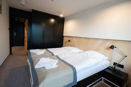 Pokój hotelowy z dwoma łóżkami i szafą.