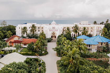 Madinat Al Bahr – hotel w kolorze białym otoczony palmami, widok z lotu ptaka.