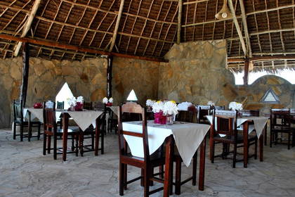 Restauracja z kamiennymi ścianami i dachem krytym strzechą.