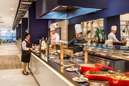 Bufet z kucharzami i obsługą w restauracji hotelowej.