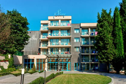 Fasada hotelu Slavy z balkonami i niebieską stolarką okienną.